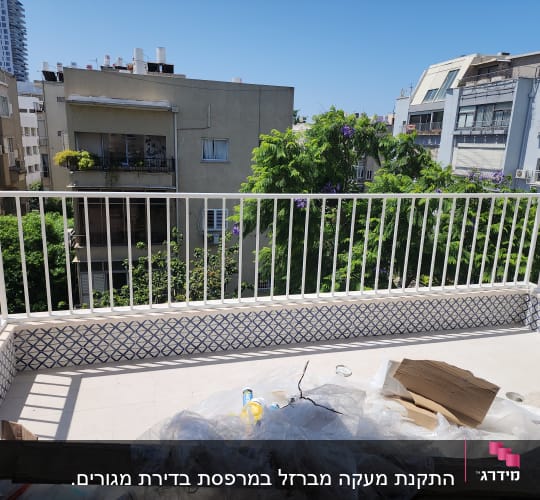 מעקה מתכת לבן על מרפסת עם אריחים מעוצבים